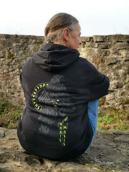 Frau sitzt mit North Legendary Hoodie im Rückenmotiv Hugin & Munin auf einer Burgmauer