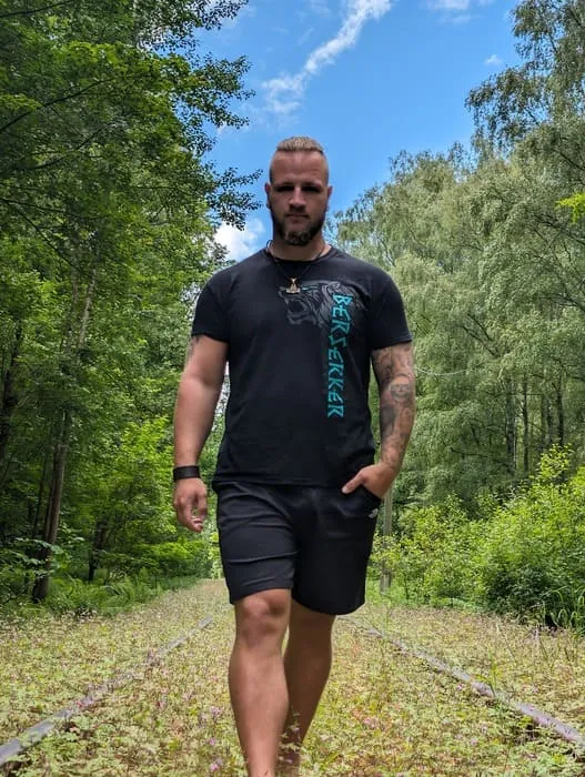 Kundin im North Legendary Shirt mit Wolfsmotiv steht in hohem Gras