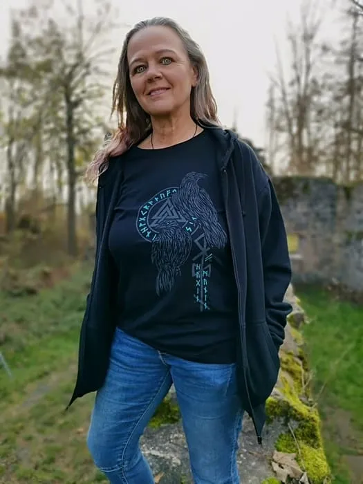 Kundin mit Hoodie und nordischem Symbol steht auf Wiese
