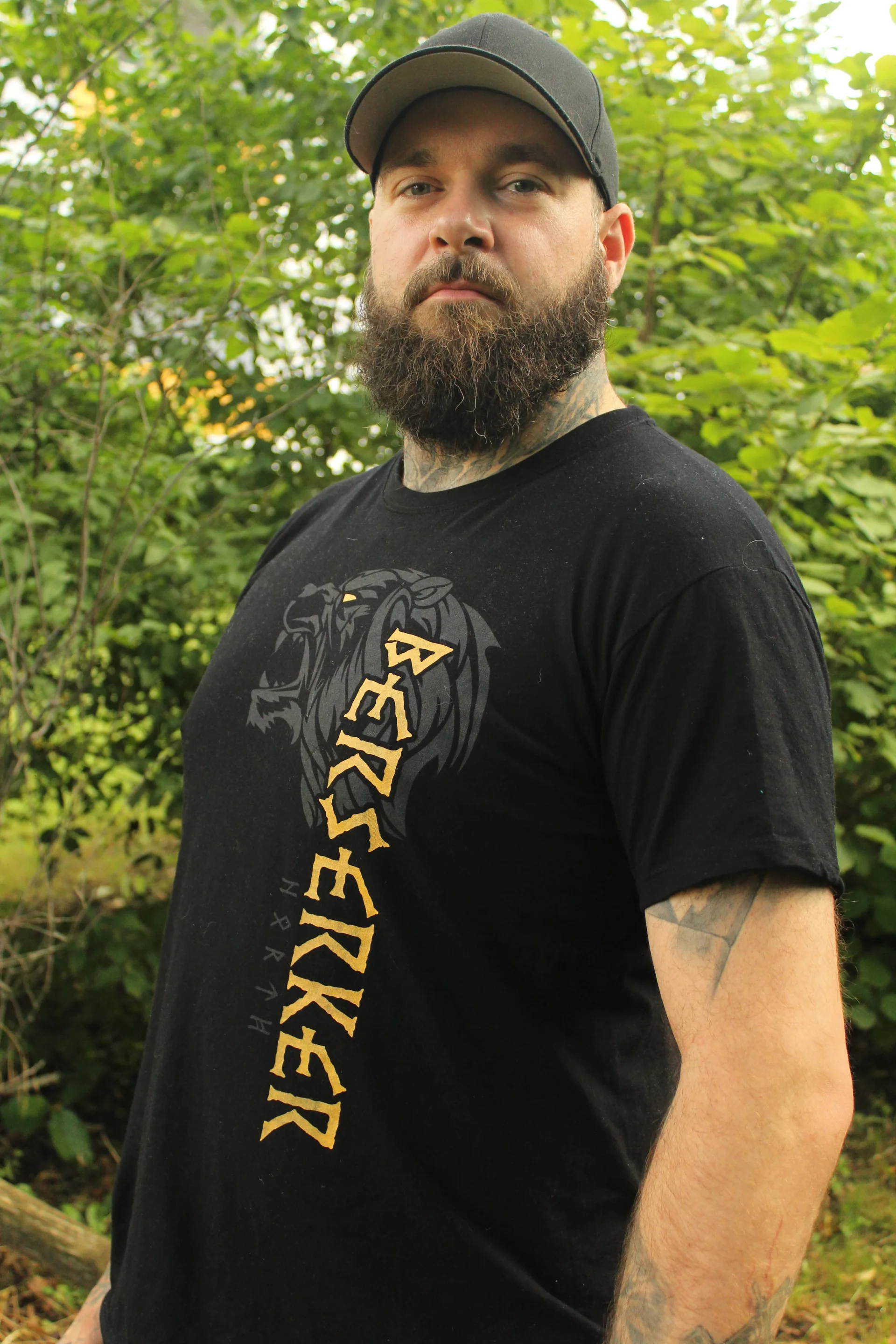 Mann mit Cap und Bart im Wald, North Legendary Berserker-Shirt mit goldenem vertikalen Print